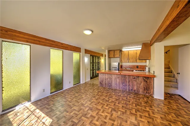 a large kitchen with kitchen island granite countertop a large window and stainless steel appliances