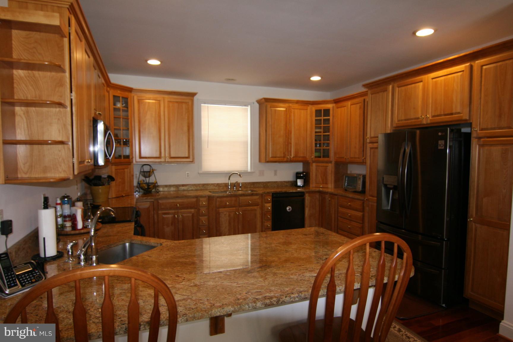 3535 Yellow Bank Road Dunkirk, MD 20754 - Photo 7 of 25 a kitchen with stainless steel appliances granite countertop a refrigerator a stove a sink a dining table and chairs