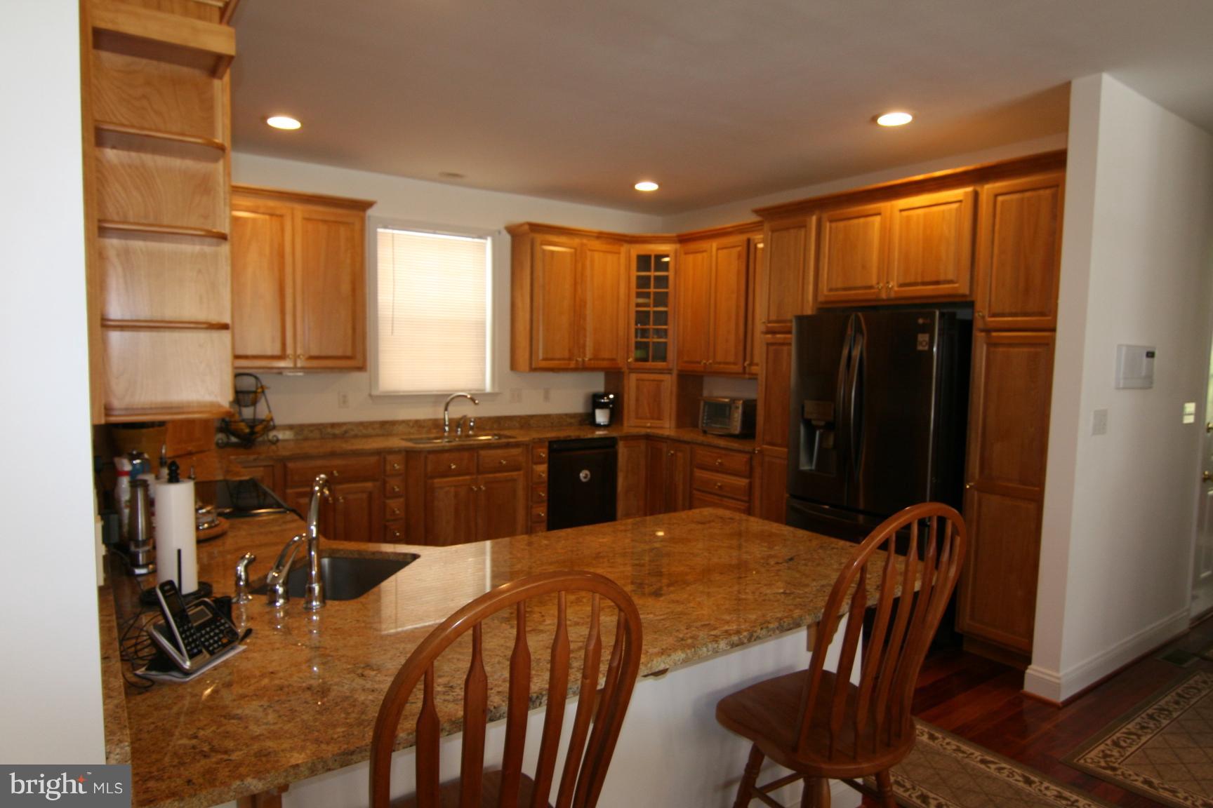 3535 Yellow Bank Road Dunkirk, MD 20754 - Photo 8 of 25 a kitchen with stainless steel appliances granite countertop a stove a refrigerator a sink a dining table and chairs