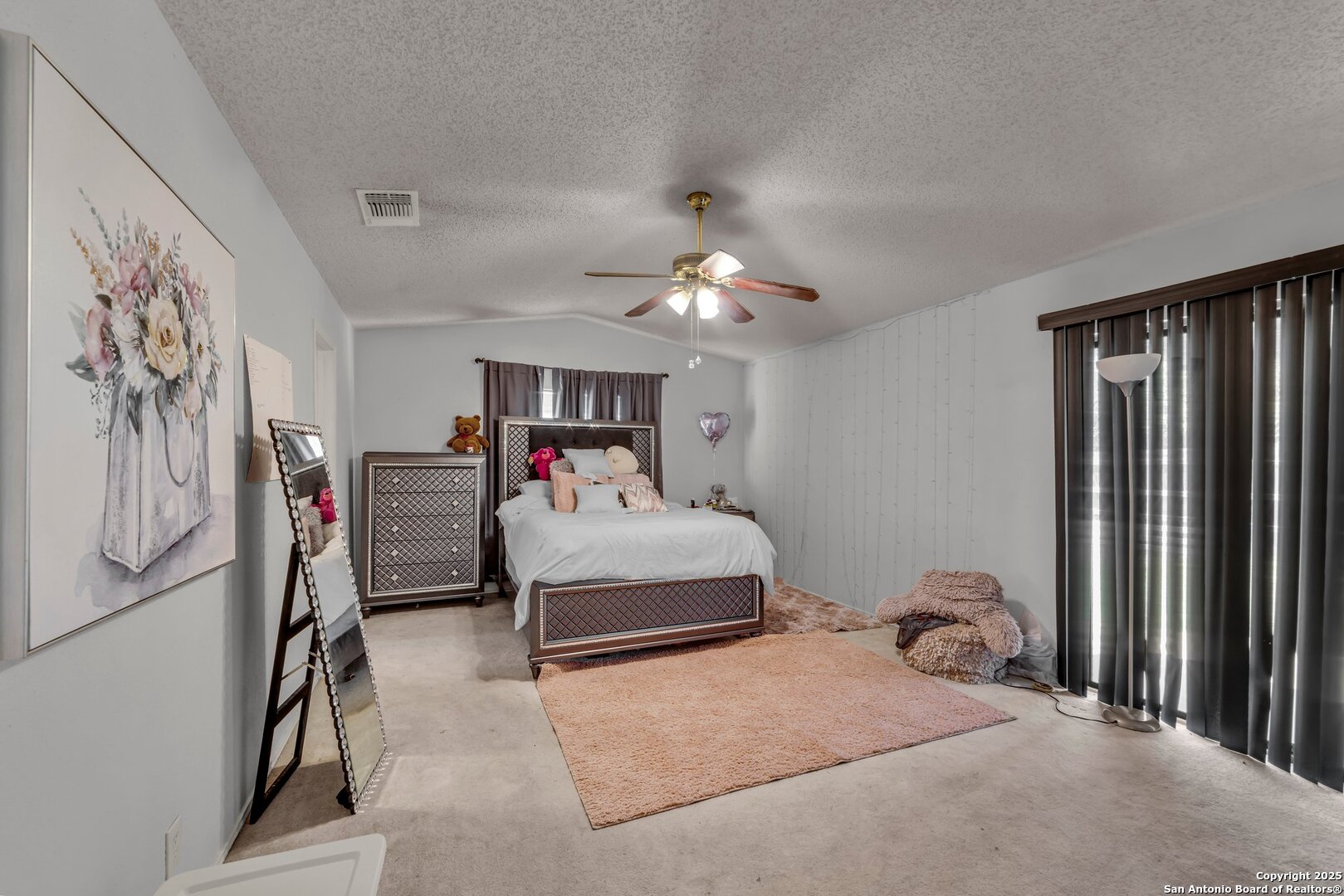 8746 Serene Ridge Drive San Antonio, TX 78239 - Photo 12 of 18 a bedroom with a bed and a chandelier