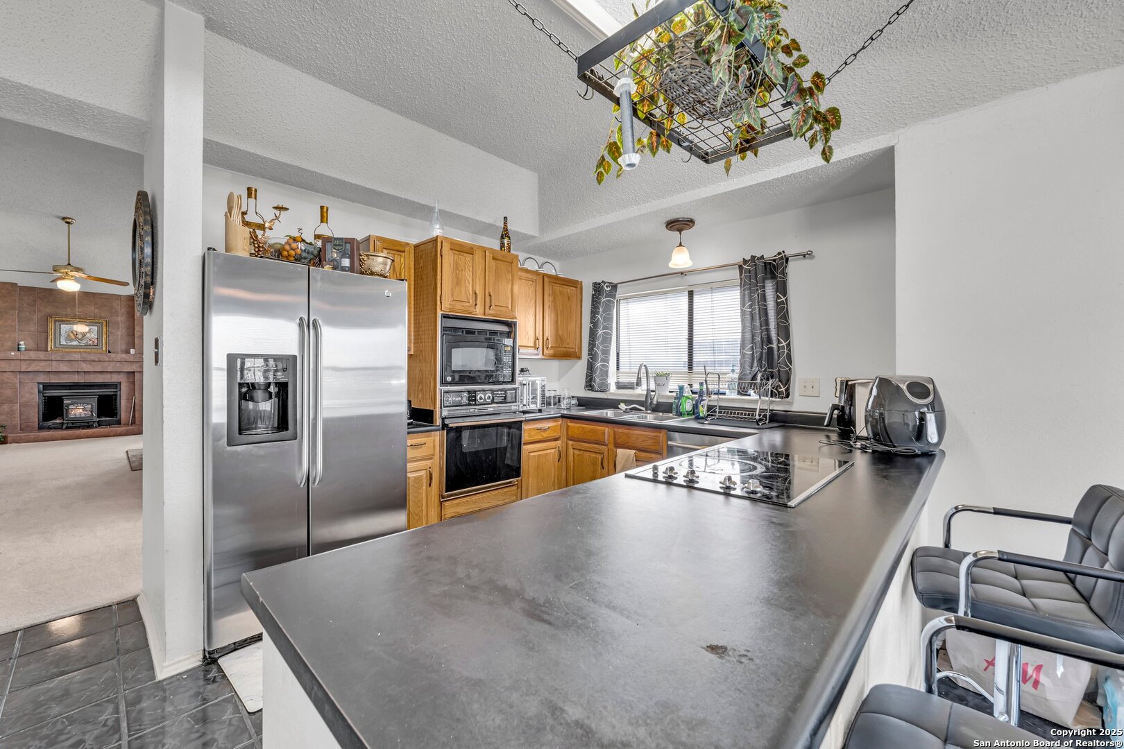 8746 Serene Ridge Drive San Antonio, TX 78239 - Photo 6 of 18 a kitchen with stainless steel appliances granite countertop a refrigerator a stove and a sink with cabinets