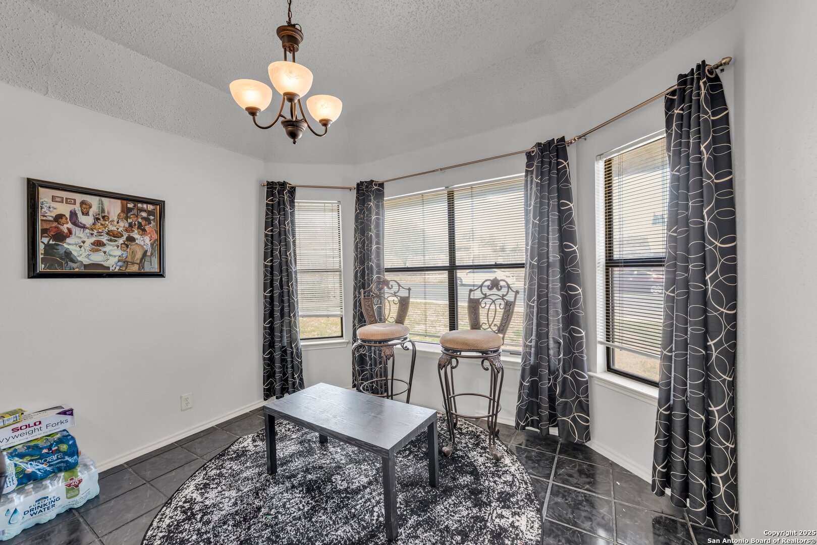 8746 Serene Ridge Drive San Antonio, TX 78239 - Photo 8 of 18 a dining room with wooden floor a chandelier a wooden table and chairs