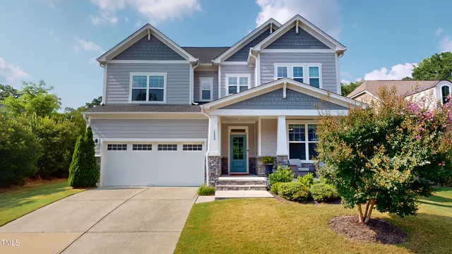 a front view of a house with a yard and potted plants