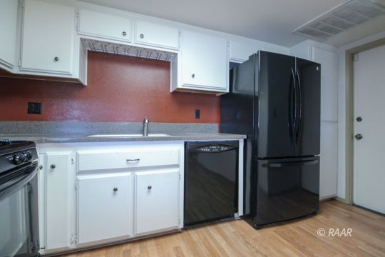 636 Heather Court Ridgecrest, CA 93555 - Photo 20 of 33 a kitchen with a refrigerator and cabinets