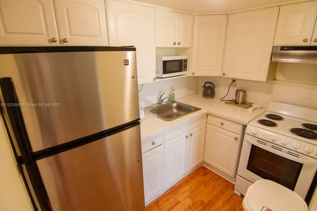 a kitchen with stainless steel appliances a refrigerator sink and cabinets