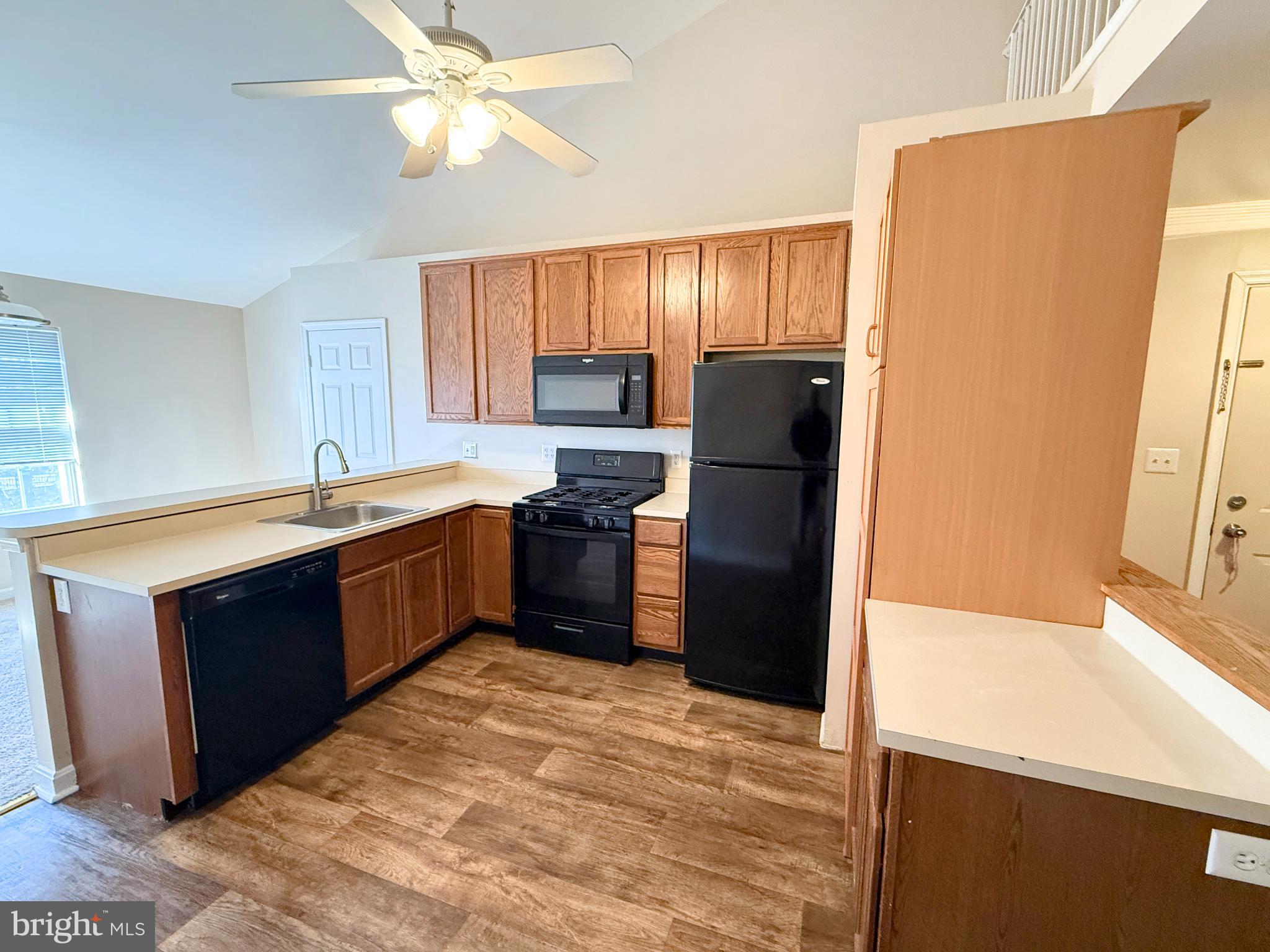 9211 Azure Court, Unit 202 Manassas, VA 20110 - Photo 4 of 16 a kitchen with a refrigerator sink and wooden cabinets