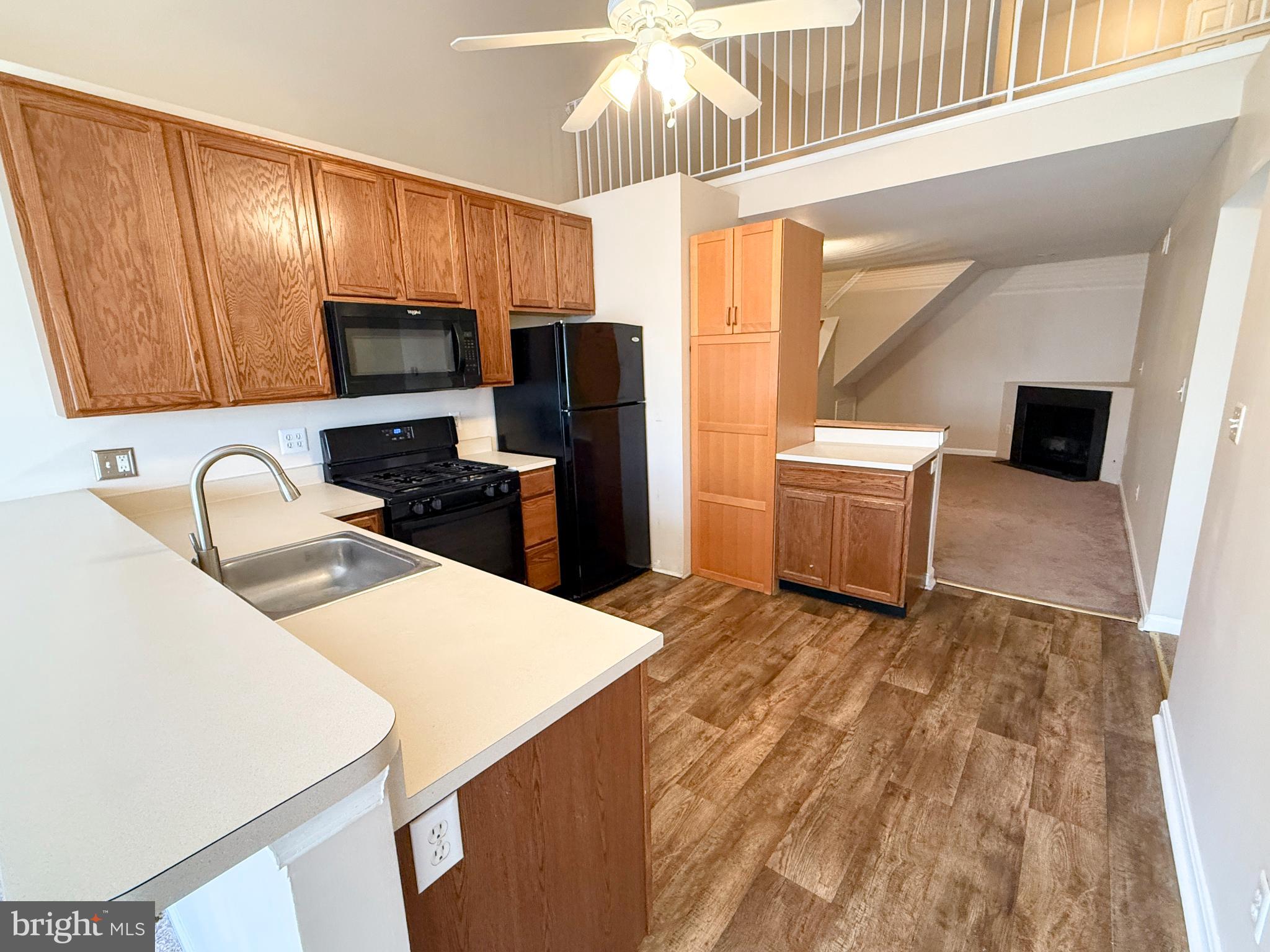 9211 Azure Court, Unit 202 Manassas, VA 20110 - Photo 5 of 16 a kitchen with a sink a stove a refrigerator cabinets and a dining table