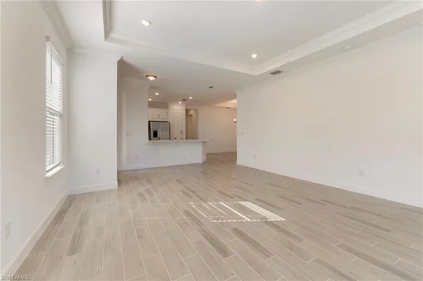 a view of a big room with wooden floor and windows