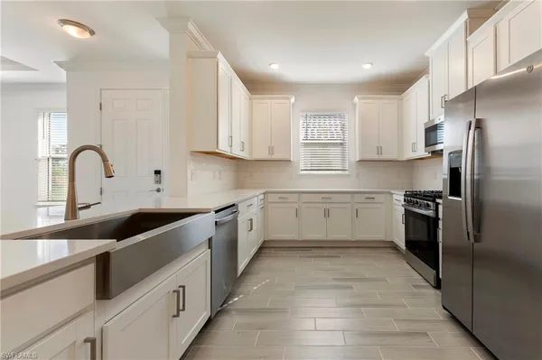 a kitchen with a sink white cabinets and stainless steel appliances
