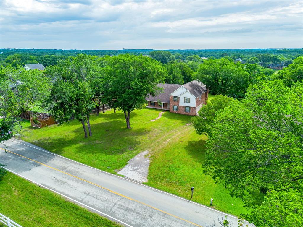 7404 John McCain Road Colleyville, TX 76034 - Photo 1 of 21 a view of a garden with lawn chairs plants and large tree