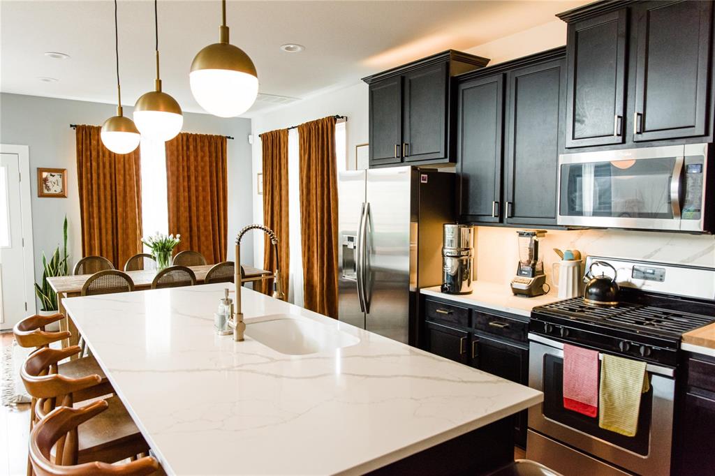a kitchen with stainless steel appliances kitchen island granite countertop a sink and a stove