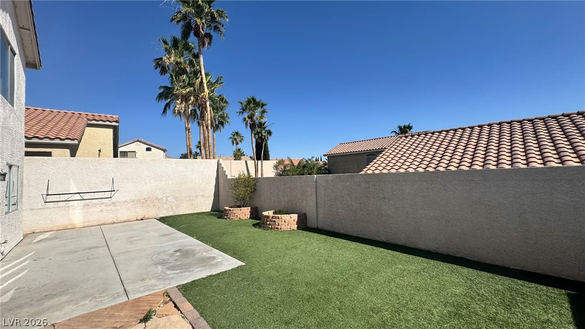 9716 Ridge Creek Place Las Vegas, NV 89134 - Photo 27 of 28 This private yard offers both paved and artificial turf areas, creating an inviting outdoor retreat.
