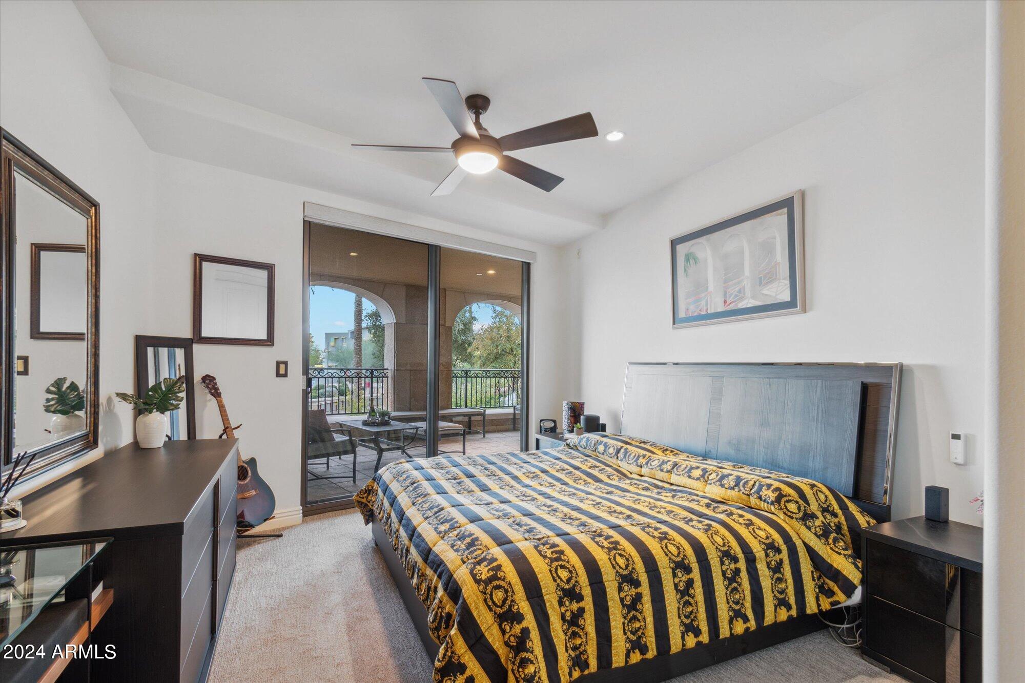 7181 East Camelback Road, Unit 206 Scottsdale, AZ 85251 - Photo 12 of 28 a bedroom with a large bed a chandelier and windows