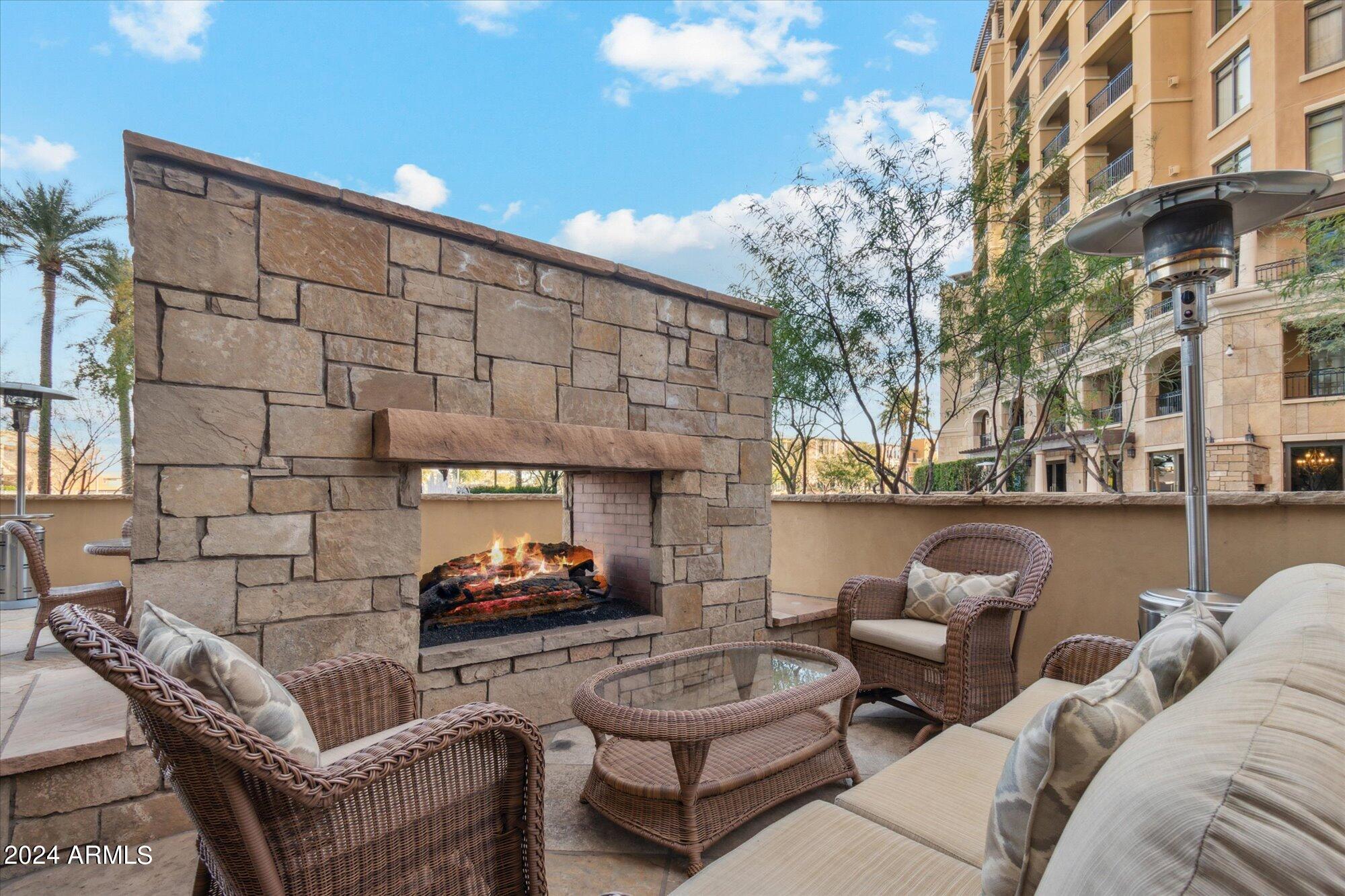 7181 East Camelback Road, Unit 206 Scottsdale, AZ 85251 - Photo 25 of 28 a outdoor living space with patio furniture and a fireplace