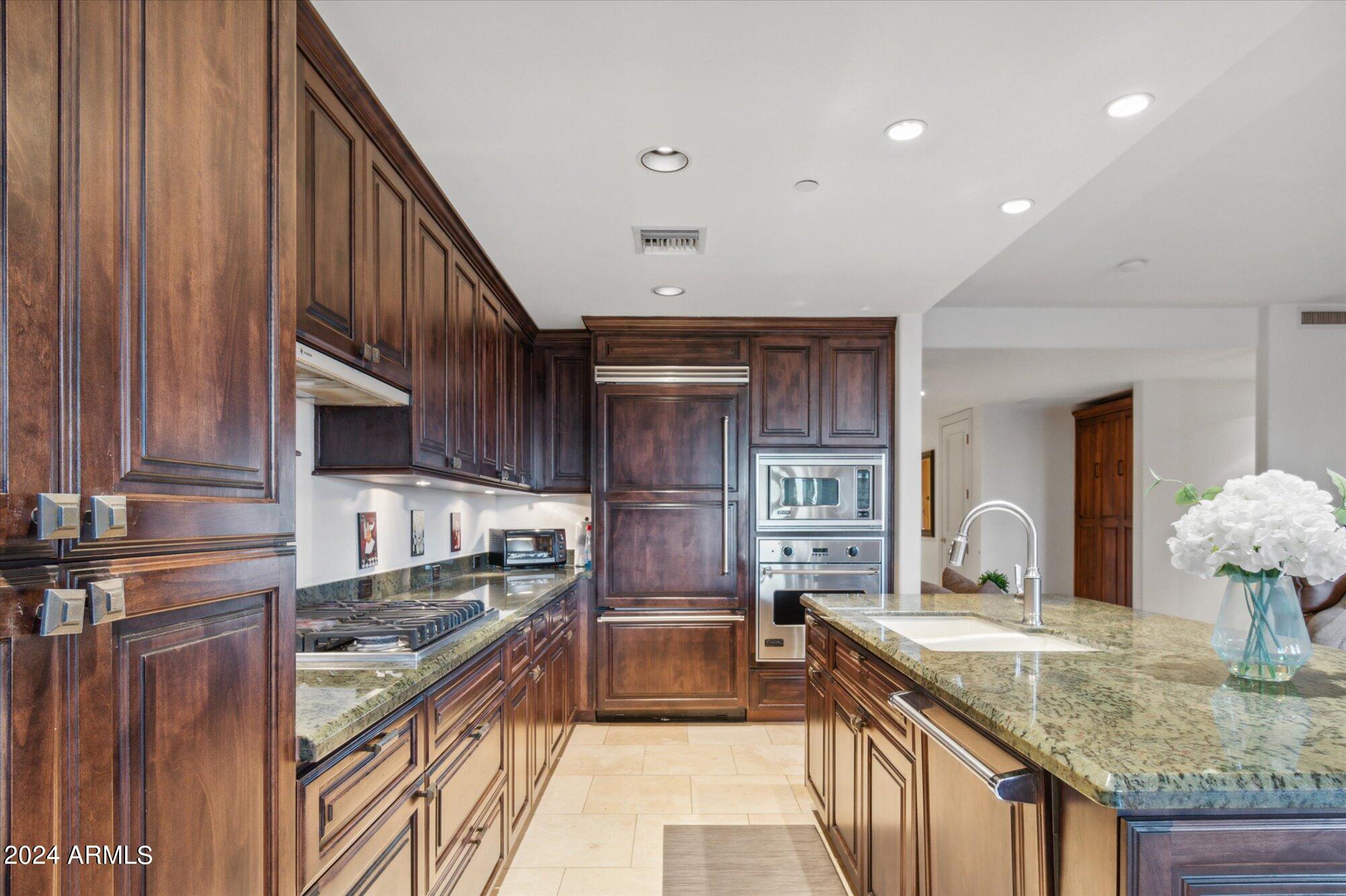 7181 East Camelback Road, Unit 206 Scottsdale, AZ 85251 - Photo 5 of 28 a kitchen with stainless steel appliances granite countertop a sink and stove