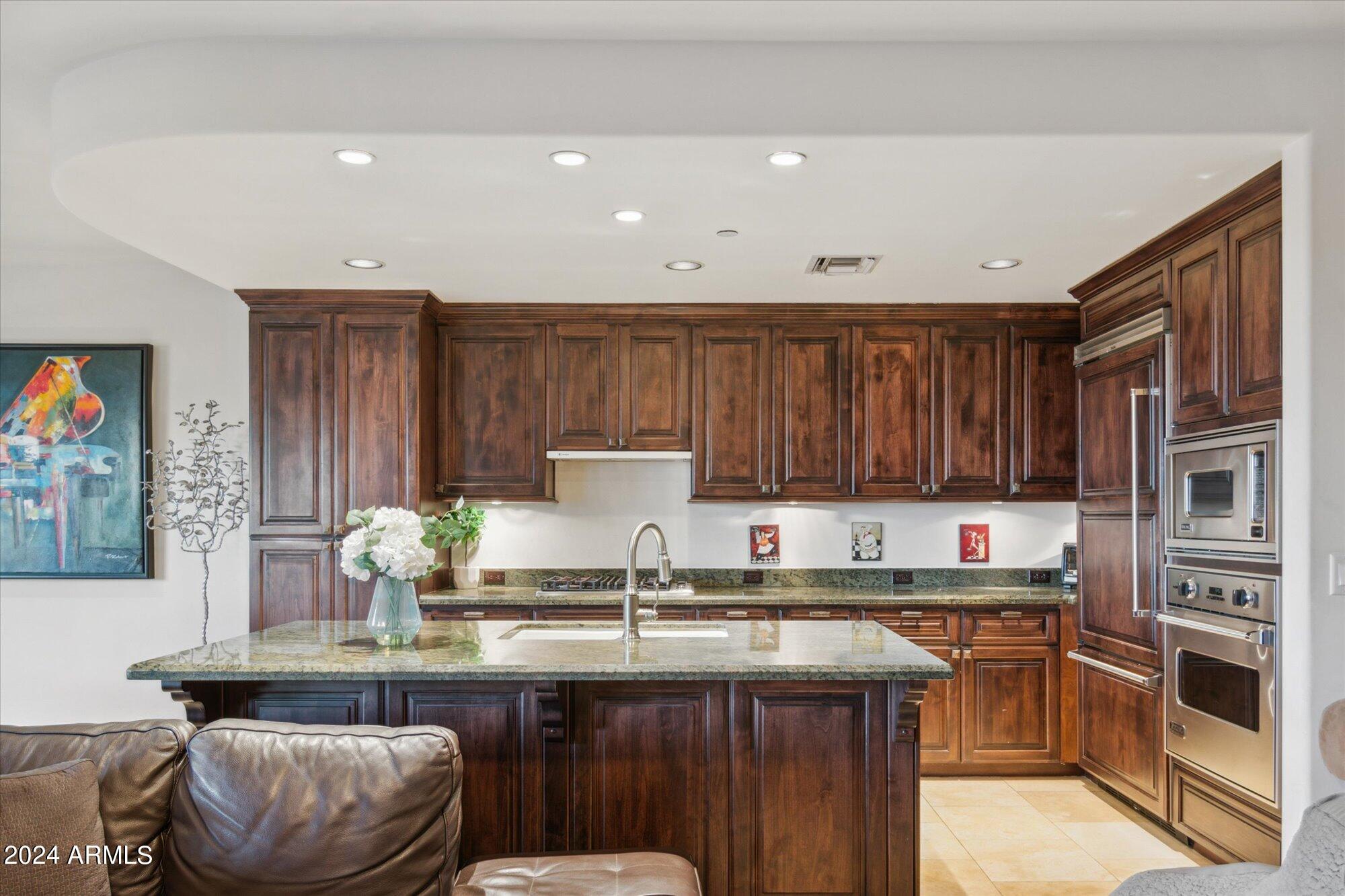 7181 East Camelback Road, Unit 206 Scottsdale, AZ 85251 - Photo 7 of 28 a kitchen with kitchen island granite countertop a table chairs stove and cabinets
