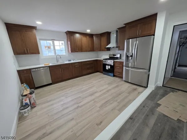 a kitchen with granite countertop a refrigerator and a sink