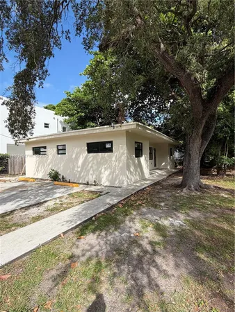 a view of a house with backyard and trees