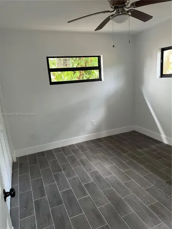 a view of a room with an empty space and a ceiling fan