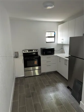 a kitchen with a stove and white cabinets