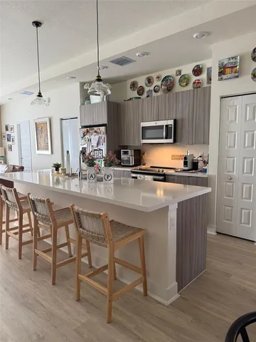 a kitchen with kitchen island granite countertop a sink and a refrigerator