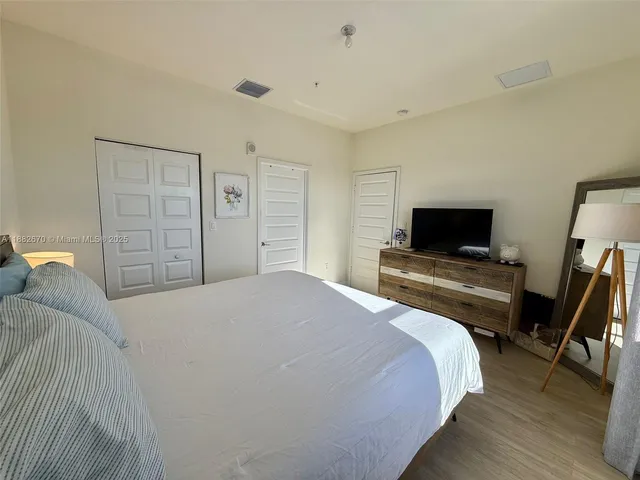 a bedroom with a bed and a flat screen tv