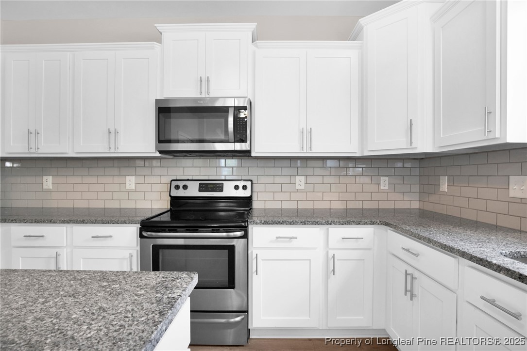 136 Loch Lane Cameron, NC 28326 - Photo 16 of 49 a kitchen with white cabinets and appliances