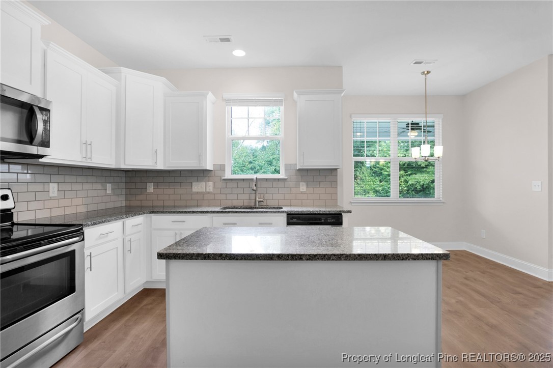 136 Loch Lane Cameron, NC 28326 - Photo 17 of 49 a kitchen with granite countertop a stove a sink and a microwave
