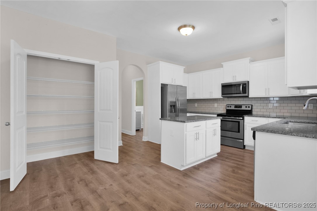 136 Loch Lane Cameron, NC 28326 - Photo 19 of 49 a kitchen with granite countertop white cabinets and stainless steel appliances