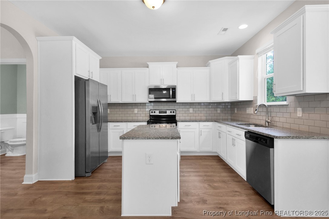 136 Loch Lane Cameron, NC 28326 - Photo 20 of 49 a kitchen with granite countertop a refrigerator and a stove top oven