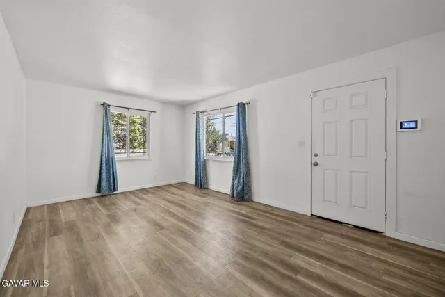 a view of a room with wooden floor and a window