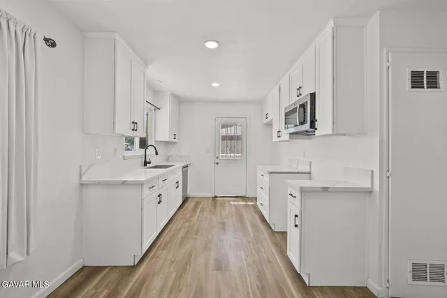 a view of a kitchen with sink cabinets and wooden floor
