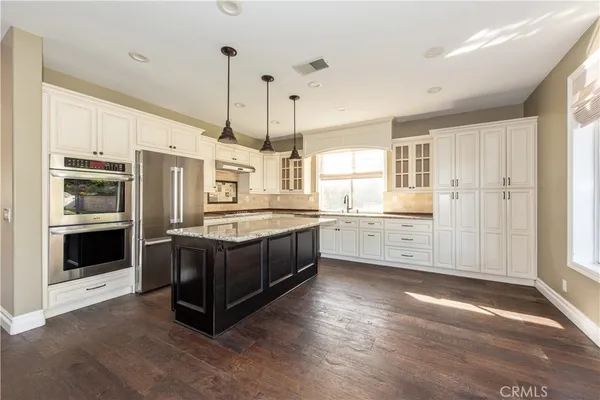 a kitchen with stainless steel appliances granite countertop a stove a sink and a refrigerator