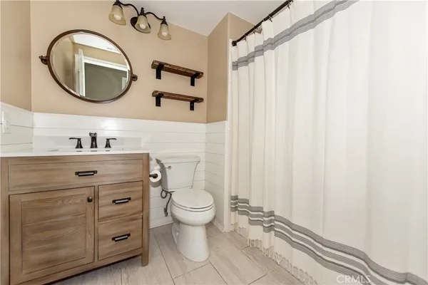 a bathroom with a toilet a sink and a mirror
