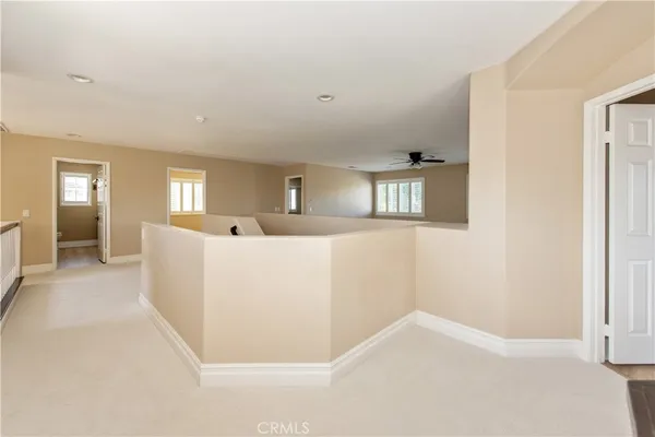 a view of a big room with windows and chandelier