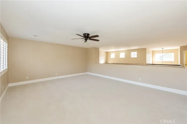 an empty room with a window and a ceiling fan