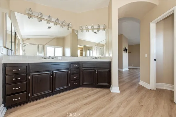 a spacious bathroom with a granite countertop sink and a mirror