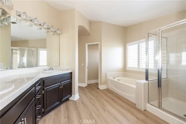 a spacious bathroom with a tub sink shower and mirror