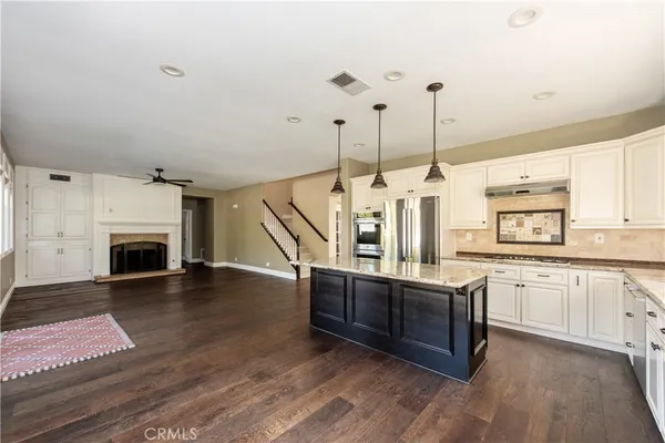 a kitchen with stainless steel appliances granite countertop a stove a sink and a wooden floors
