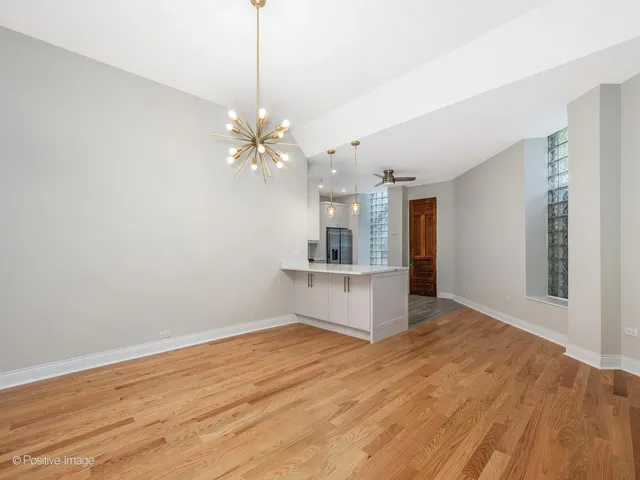 a view of a room with wooden floor and a ceiling fan