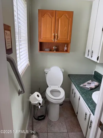 a bathroom with a granite countertop toilet and a sink