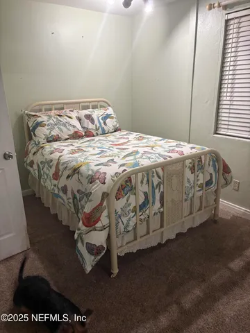 a bed sitting in a bedroom next to a window