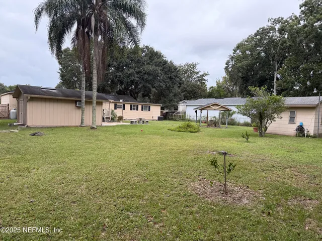 a backyard of a house with plants and palm trees