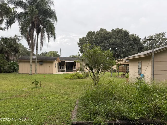 a view of a house with backyard and a garden