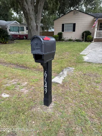 a front view of a house with a garden and trees