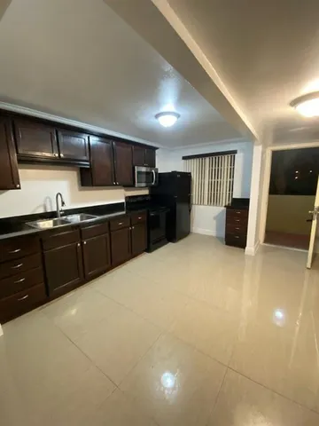 a large kitchen with stainless steel appliances granite countertop a sink and cabinets