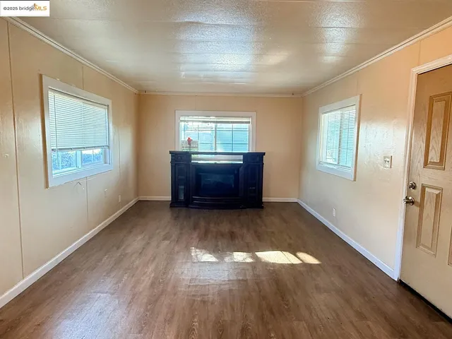 a big room with wooden floor and windows