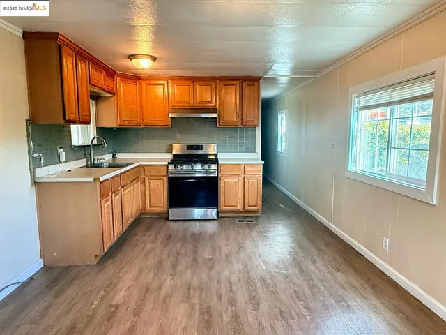 a kitchen with stainless steel appliances granite countertop a stove a sink dishwasher and a refrigerator