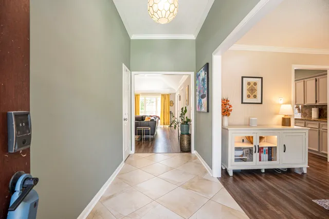 a view of a hallway with wooden floor and a kitchen
