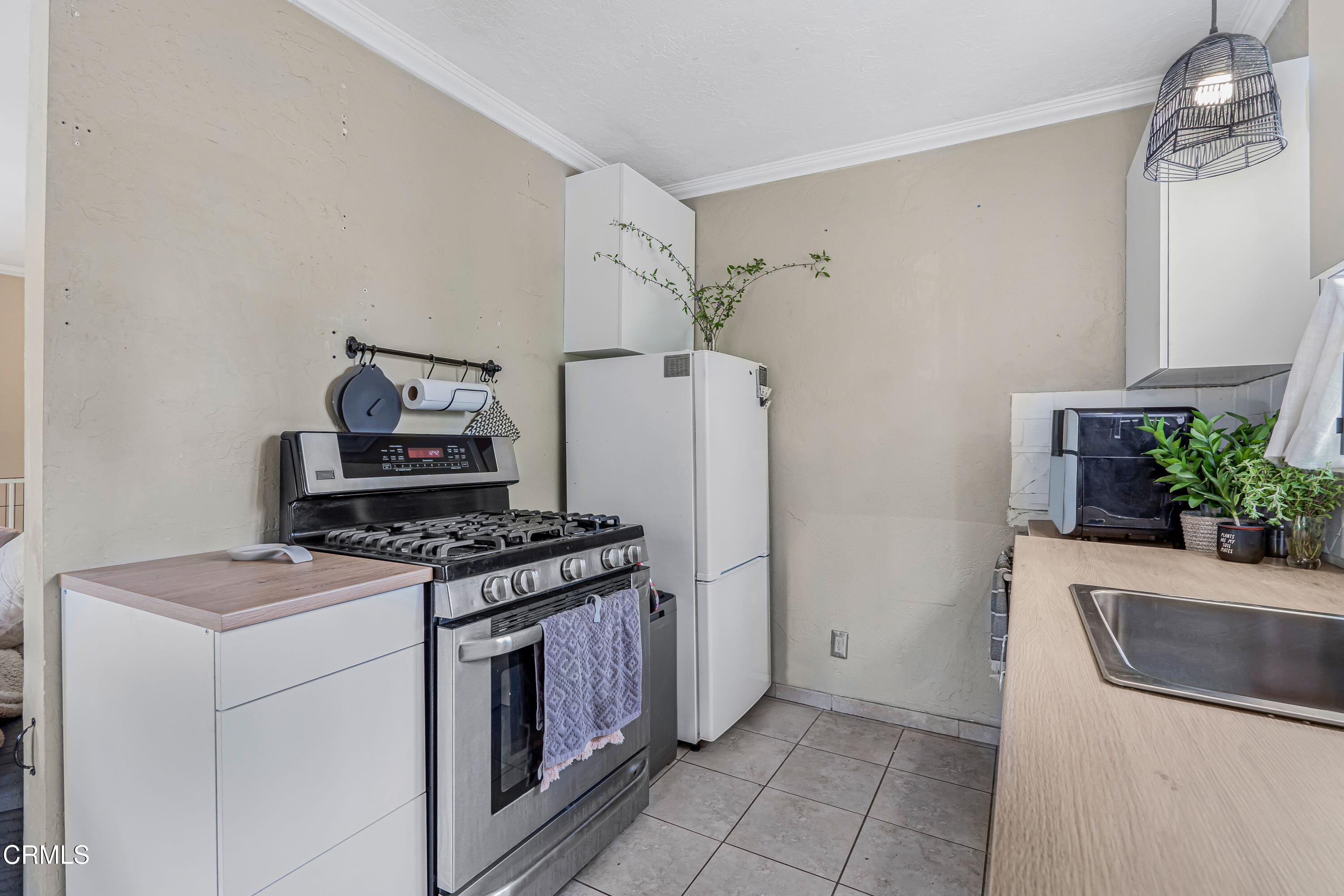 6045 Oak Knolls Road Simi Valley, CA 93063 - Photo 11 of 25 a kitchen with a stove and a refrigerator